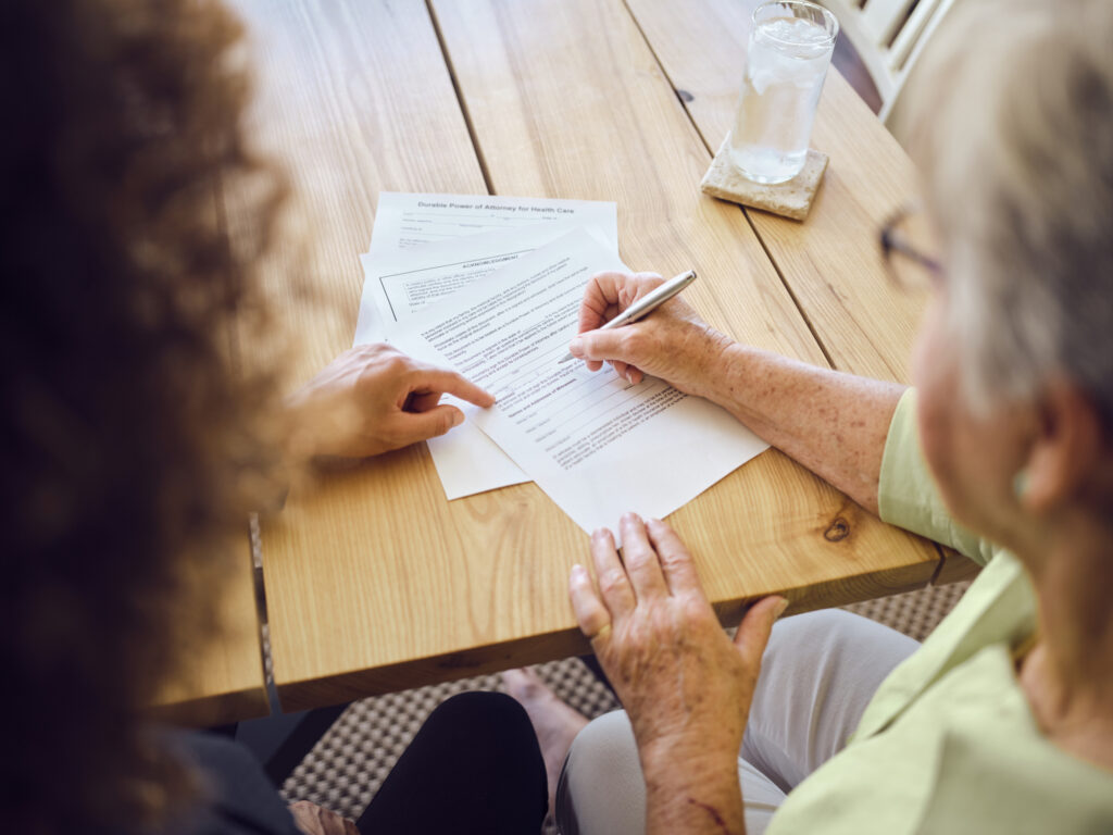 Elderly lady and younger woman writing down an estate plan.